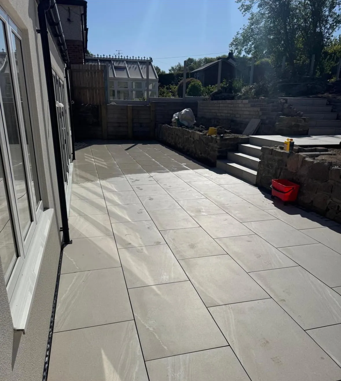 Porcelain patio laid outside patio doors during a garden build