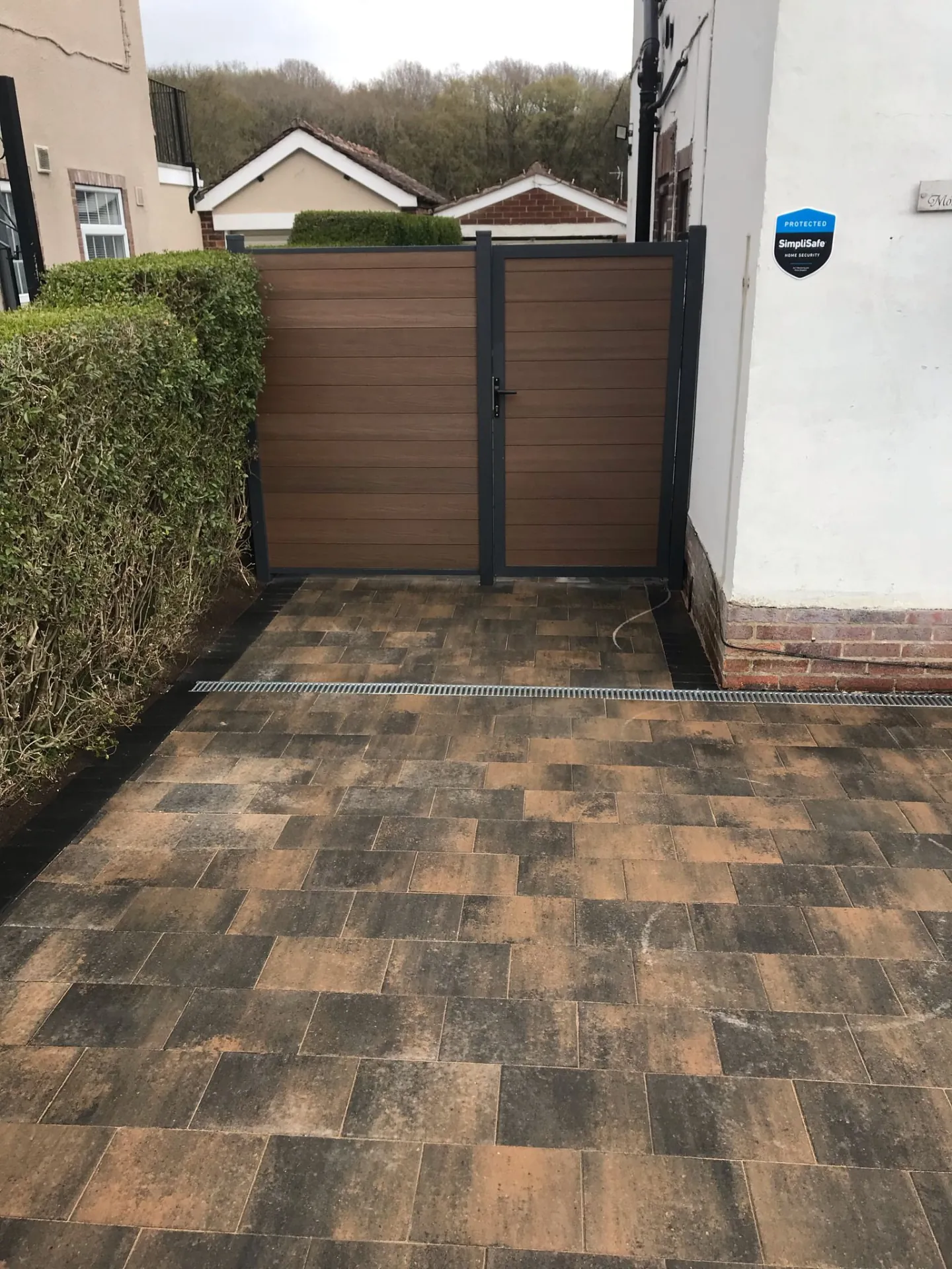 Multi-tone block paved side entrance leading to a composite gate