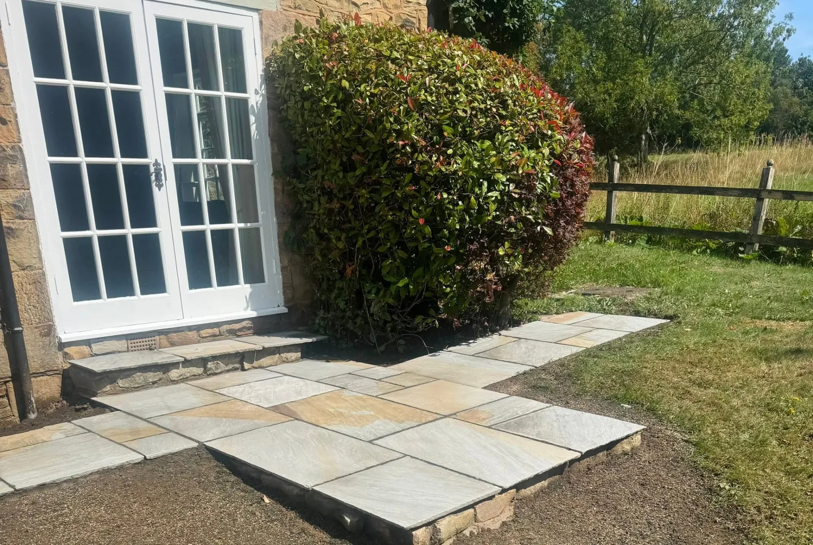 Flagstone patio and path laid beside a stone house