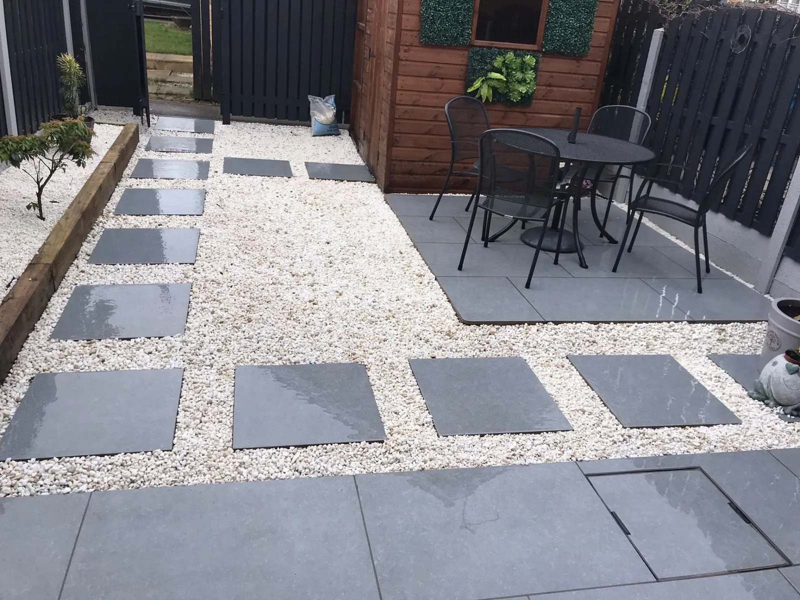 Slate stepping stones set in white gravel leading to a paved seating area