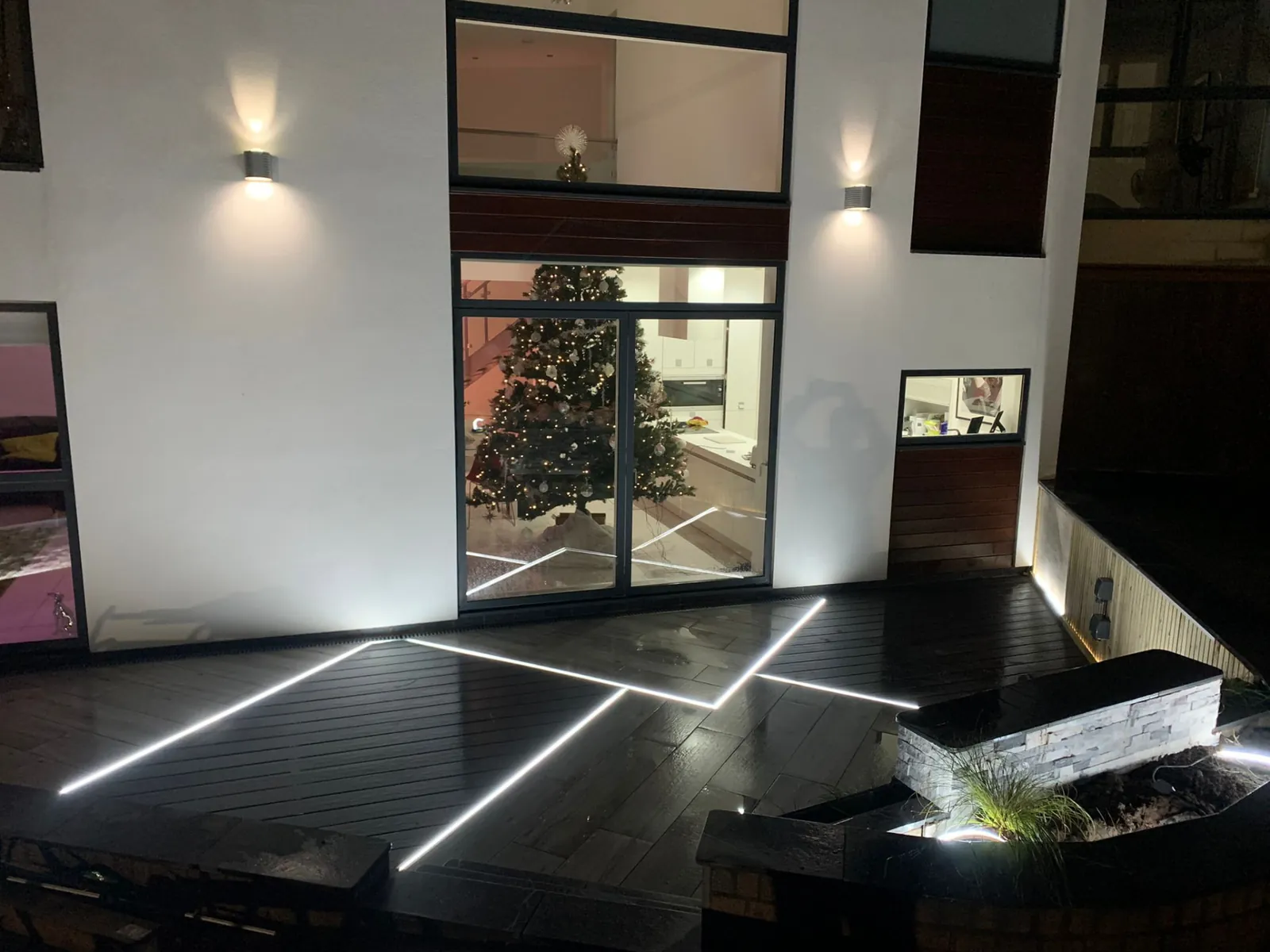 Dark composite decking with inset LED strip lighting at night