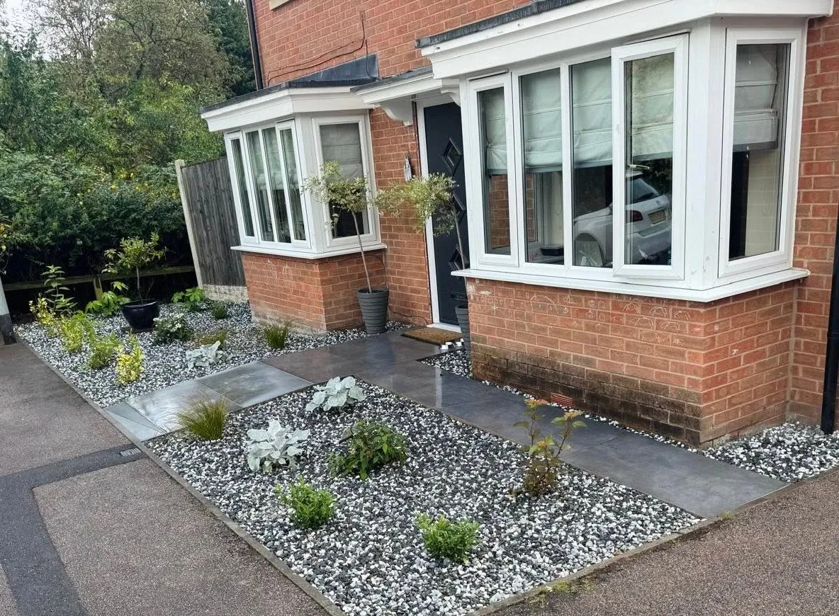 Front garden makeover with gravel beds, shrubs and a dark paved path
