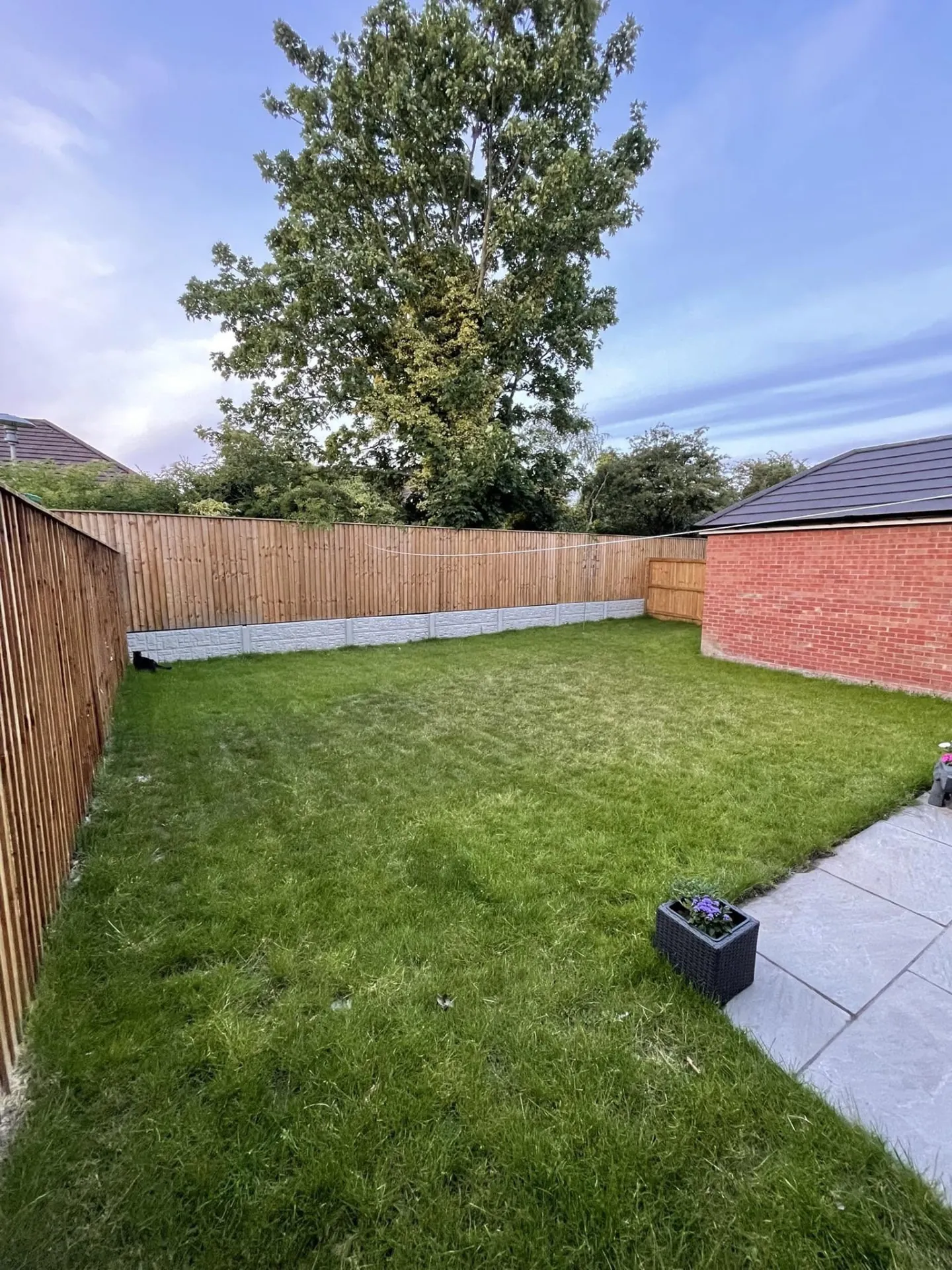 New build garden before landscaping, with a plain lawn and basic patio