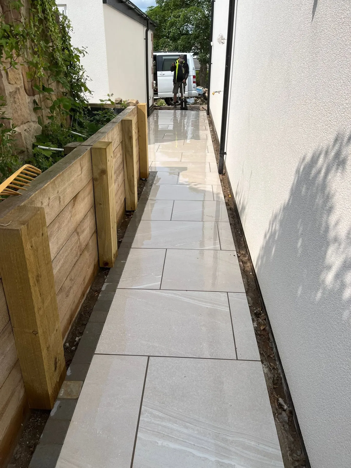 Porcelain side path being laid beside a timber sleeper wall