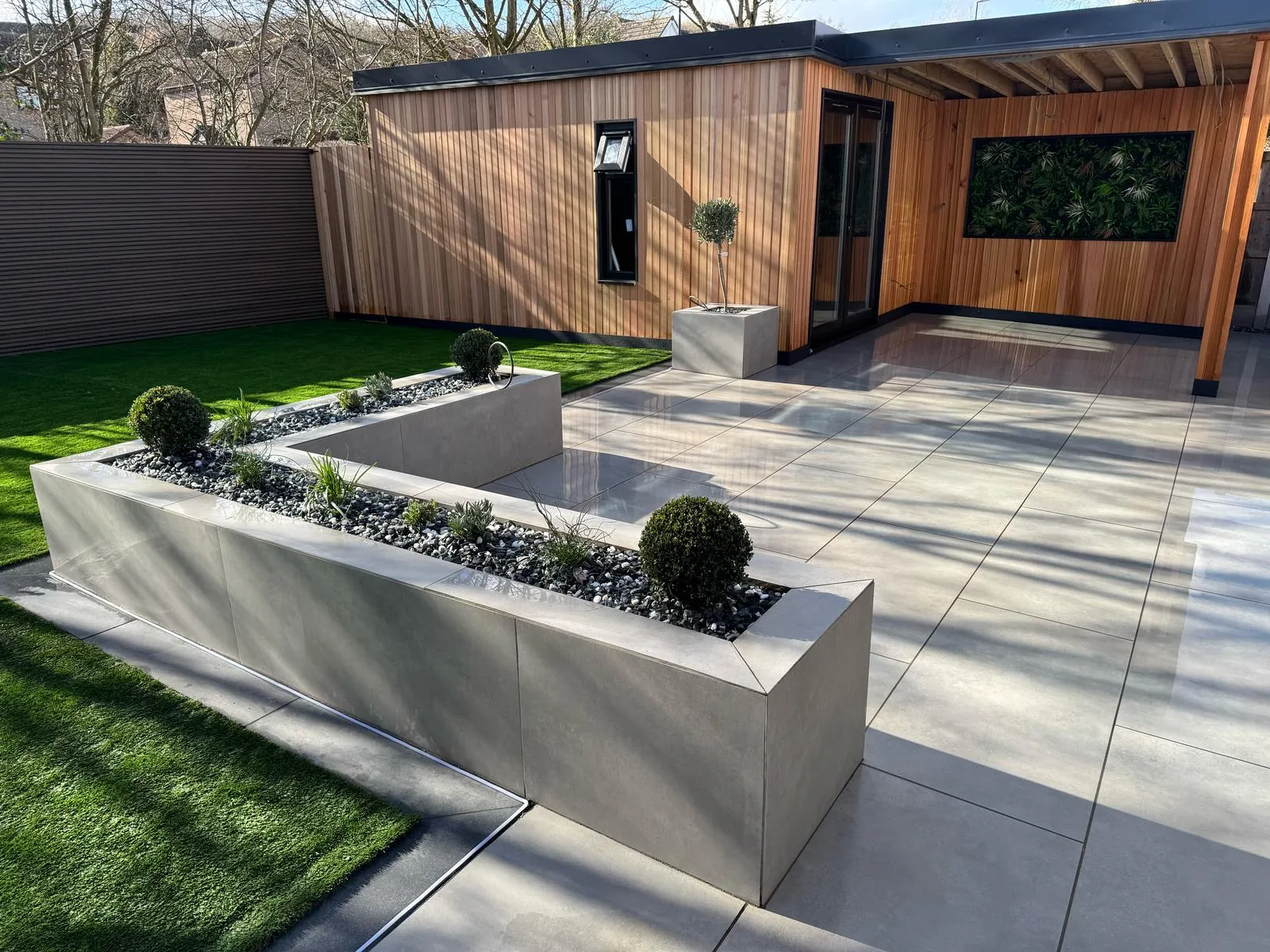 Cedar-clad garden room with porcelain patio and rendered raised planter