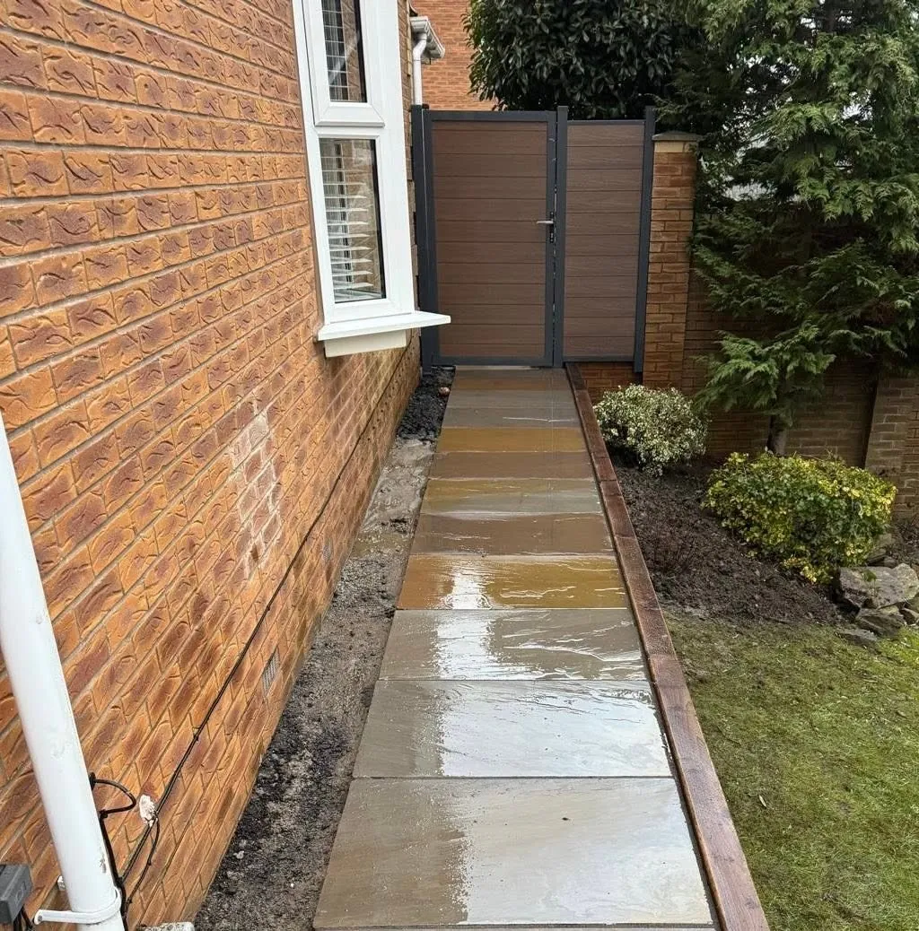 After: Sandstone path along a brick house leading to a side gate