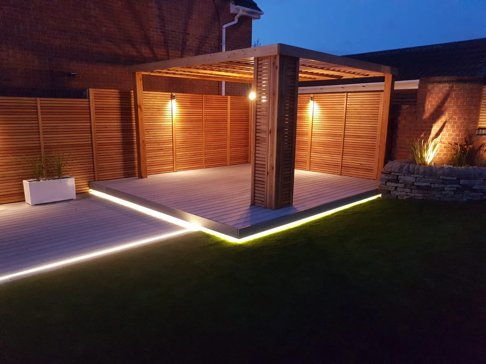 Composite decking with LED lighting under a timber pergola at night