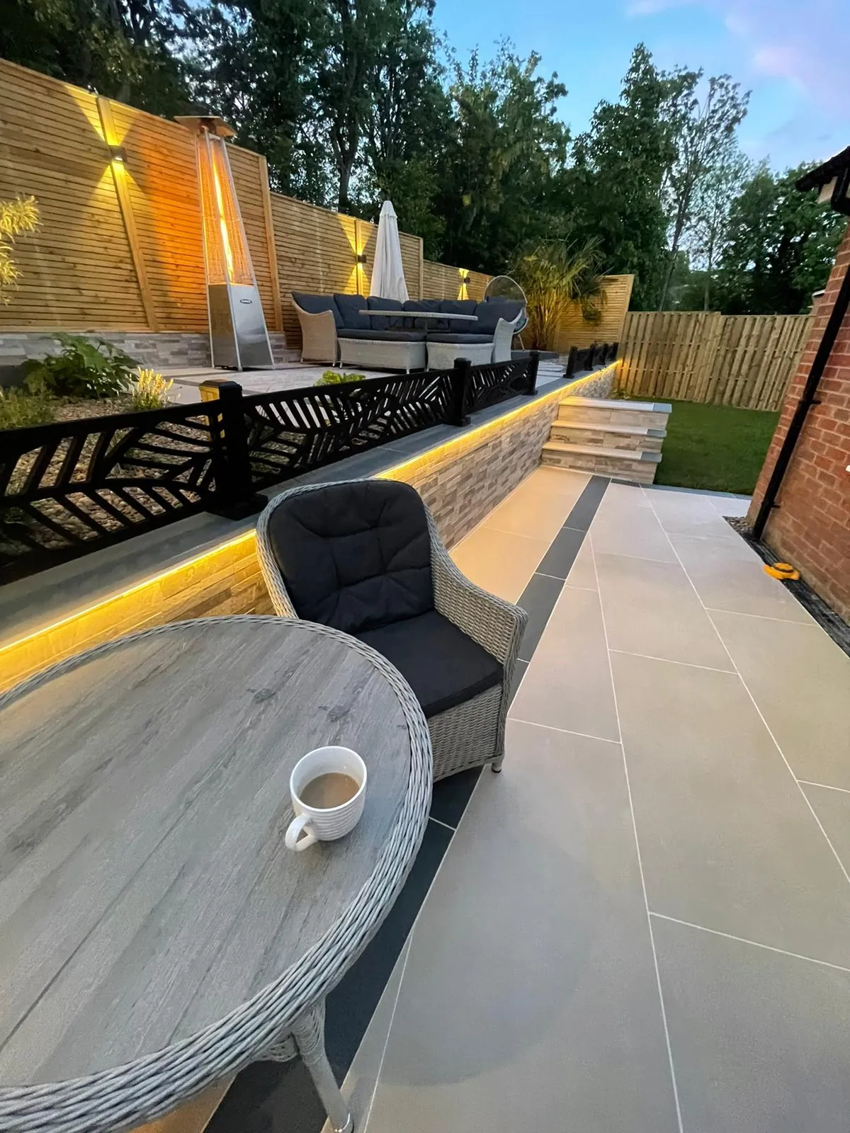 Porcelain patio with lit raised wall and garden seating