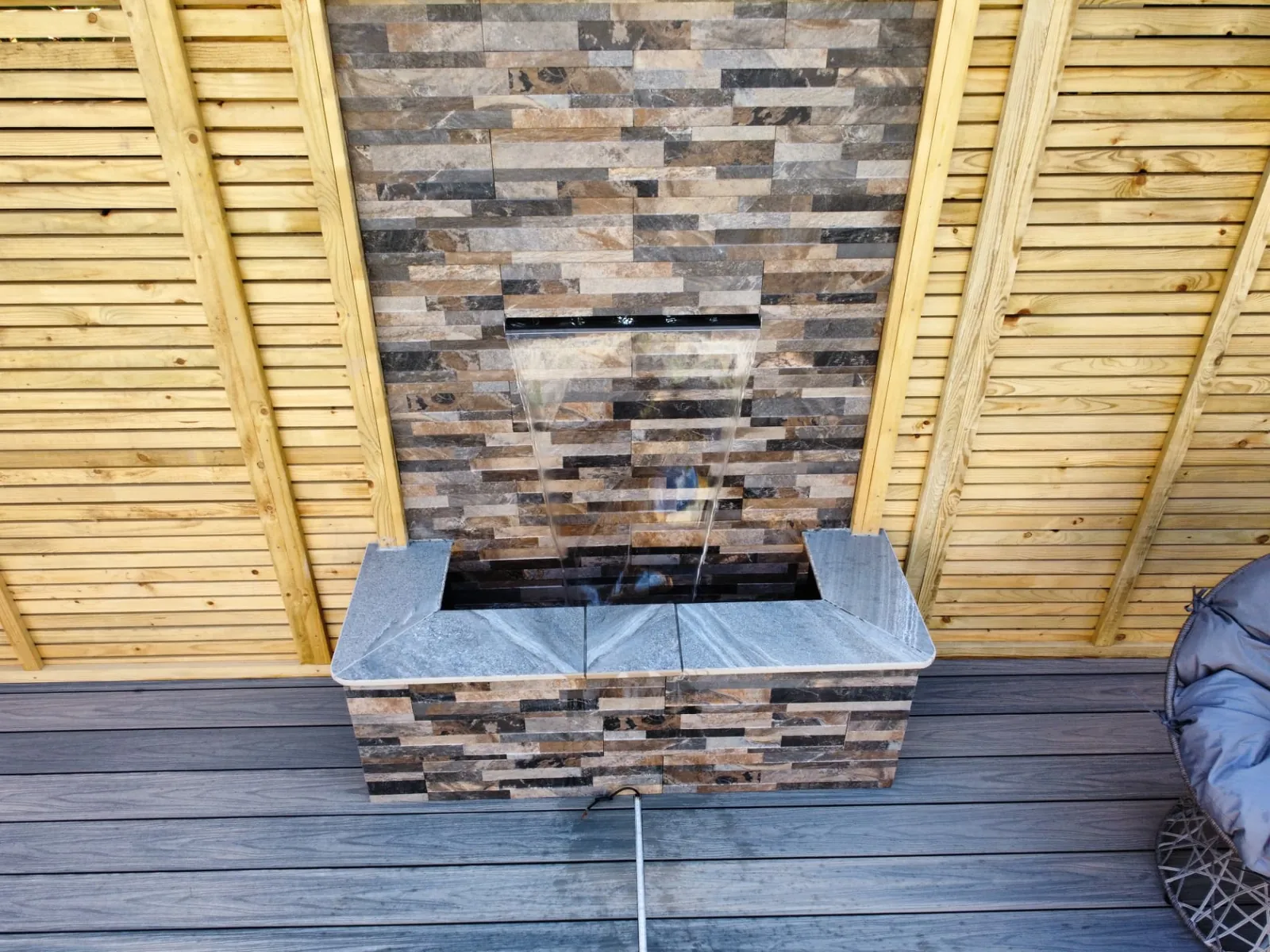 Stone-clad wall water feature on composite decking